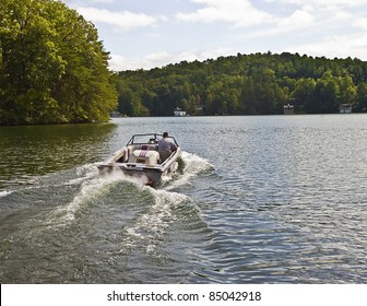 Man Driving A Ski Boat In A Lake.