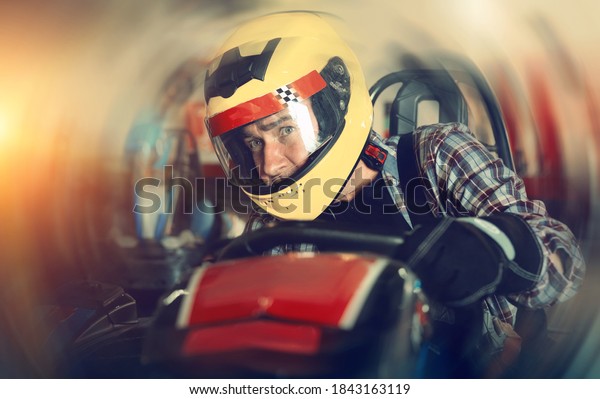 Man driving sport car in a circuit lap in\
karting club, people on\
background