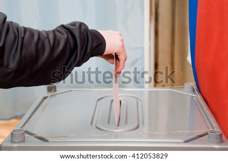 The man drops his ballot in the ballot box. Elections