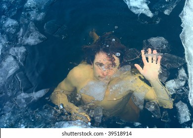 Man drowning in cold winter water with ice on surface