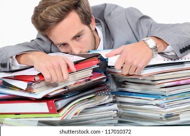 Man Drowning In Stacks Of Paperwork