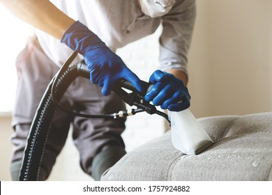 Man Dry Cleaner's Employee Hand In Protective Rubber Glove Cleaning Sofa With Professionally Extraction Method. Early Spring Regular Cleanup. Commercial Cleaning Company Concept. Closeup