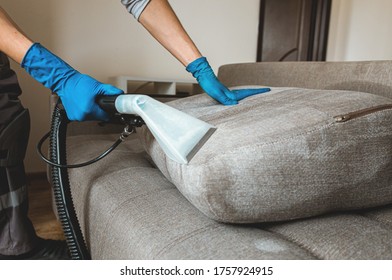 Man dry cleaner's employee hand in protective rubber glove cleaning sofa with professionally extraction method. Early spring regular cleanup. Commercial cleaning company concept - Shutterstock ID 1757924915