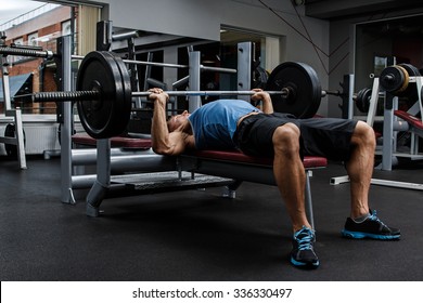 Man during bench press exercise in gym - Shutterstock ID 336330497