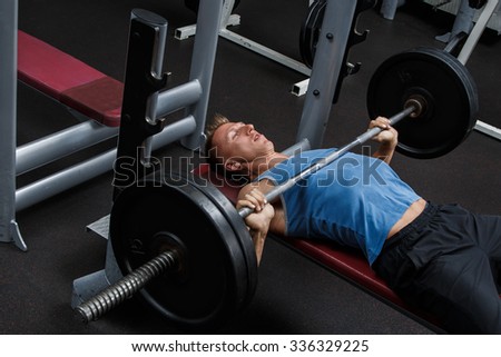 Man during bench press exercise in gym