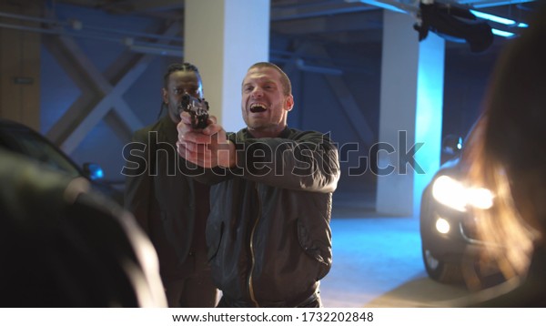 A man\
during a deal in a parking lot pulls a\
gun