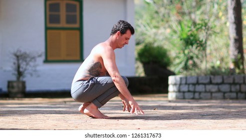 Man Dusting Off Hands By Cleaning With Pants, Preparing To Exercise