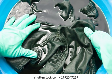 man dyeing clothes in bucket - Shutterstock ID 1792347289