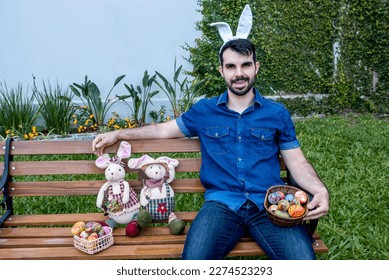 man with easter bunny ears on park bench