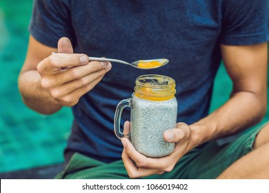 Man Eat Dessert With Chia Seeds And Mangoes By The Pool In The Morning. Healthy Eating, Vegetarian Food, Diet And People Concept