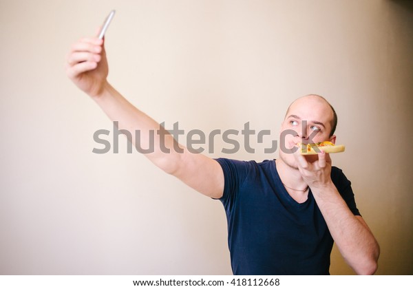 Man eat pizza, make selfie. Unhealthy food. Unhealthy
Lifestyle. 
