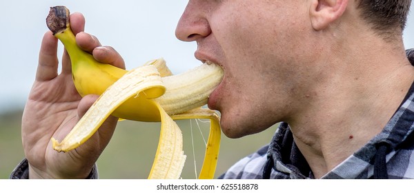 A Man Is Eating A Banana