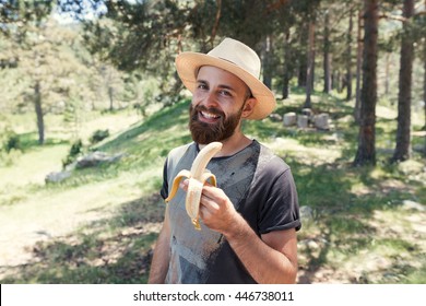 Man Eating A Banana In Nature