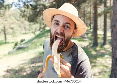 Man Eating A Banana In Nature