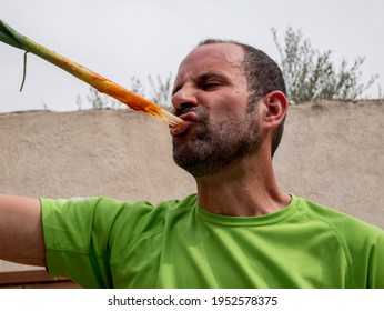 Man Eating Barbecue Of Spring Onion Shoots With Tomato Sauce, Typical Spanish Product Of The Region Of Catalonia