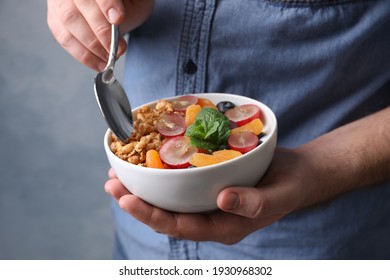 Man Eating Delicious Granola With Fruits, Closeup