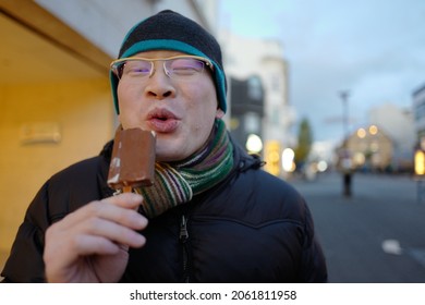 A Man Eating Drumstick In A Very Cold Weather But He Is Enjoying