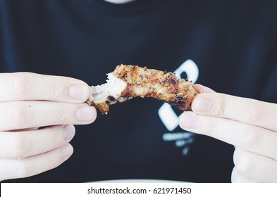 A Man Eating Grilled Pork Ribs.