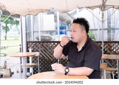 A Man Eating Ice Cream At A Cafe