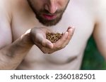 Man eating mealworms, concept of survivalism and alternative diet. Selective focus