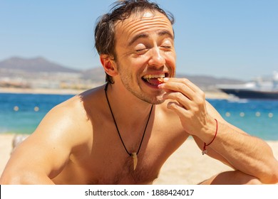 Man Is Eating Nuts On The Beach 