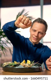 Man Eating Oysters At The Table