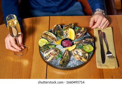 Man Eating Oysters At The Table