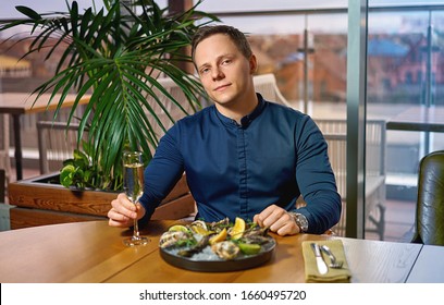 Man Eating Oysters At The Table