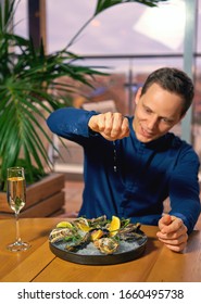 Man Eating Oysters At The Table