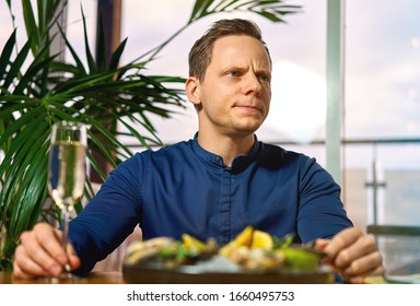 Man Eating Oysters At The Table