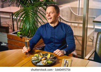 Man Eating Oysters At The Table