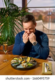 Man Eating Oysters At The Table