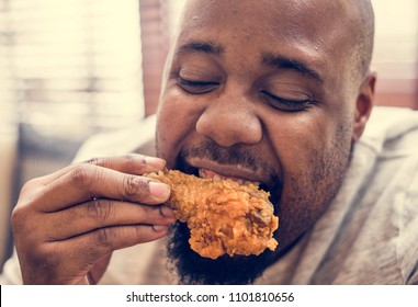 Man Eating A Piece Of Fried Chicken