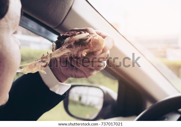 Man eating\
pizza while driving car\
dangerously
