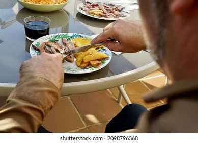 Man Eating Plate Of Iberian Secret And Chips. Table. Spanish Food. Mediterranean Food