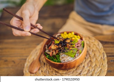 Man Eating Poke Bowl With Shrimp, Corn, Avocado, Ginger And Mushrooms