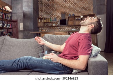 Man Eating Popcorn While Watching Movie At Home