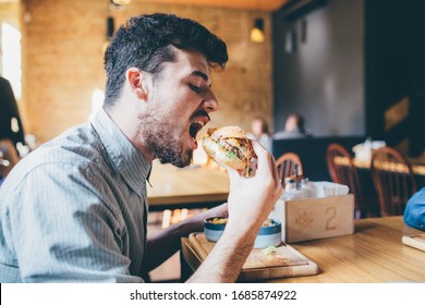Man is eating in a restaurant and enjoying delicious food - Shutterstock ID 1685874922