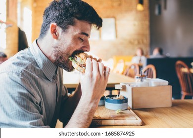 Man is eating in a restaurant and enjoying delicious food - Shutterstock ID 1685874925