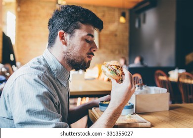 Man is eating in a restaurant and enjoying delicious food 