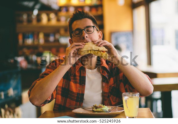 男性はレストランで食べ 美味しい食べ物を楽しんでいます の写真素材 今すぐ編集