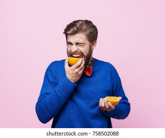 Man eating sour an orange