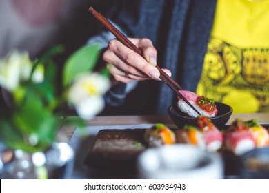 Man eating sushi set with chopsticks on restaurant