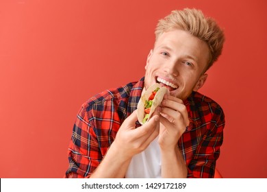 Man Eating Tasty Taco On Color Background