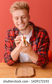 Man Eating Tasty Taco On Color Background