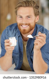 Man Eating A Yogurt