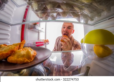 Man eats bread rolls, the view from the refrigerator - Powered by Shutterstock