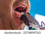 man eats chocolate ice cream with toppings on sticks with his mouth open wide