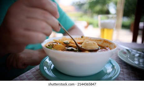Man eats Tom yam soup. Bowl of Thai ,Tom Yam seafood soup