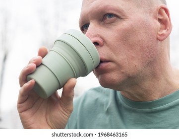 Man With Eco Reusable Coffee Cup Or Silicon Tea Mug And Drinking, Close Up.